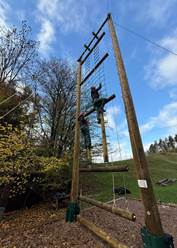 A person climbing a roped ladder activity